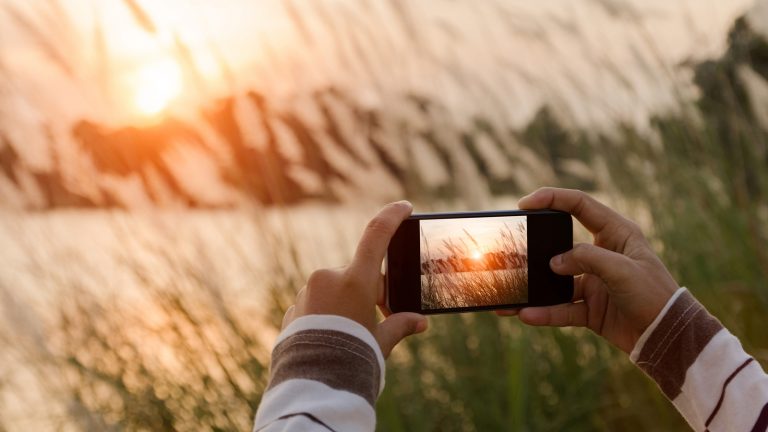 Handy für Fotos mit zwei Händen halten Handy für Fotos mit zwei Händen halten