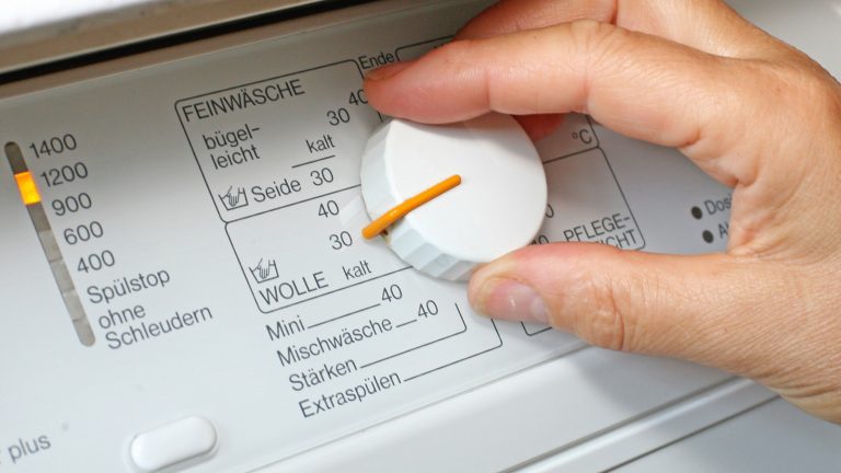 Auswählen des richtigen Waschprogramms Hand stellt Waschmaschinenregler um