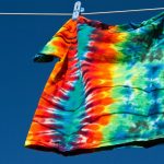T-Shirt mit Batik-Mustern wird auf einer Leine getrocknet