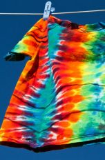 T-Shirt mit Batik-Mustern wird auf einer Leine getrocknet