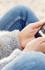 Nutzerin hält Smartphone mit aktivierter Cortana-App in der Hand
