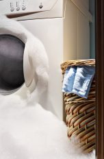 Schaumiges Wasser tritt aus Waschmaschine aus