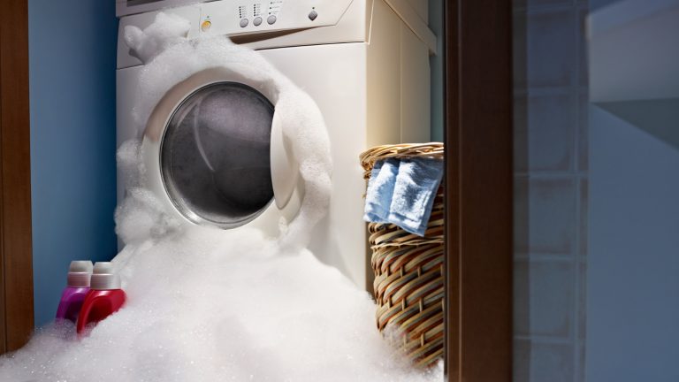 Schaumiges Wasser tritt aus Waschmaschine aus