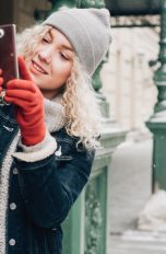 Eine Person ist im Winter draußen und macht mit dem Handy Fotos.nter draußen und macht mit dem Handy Fotos.