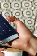 Großaufnahme Männerhand hält Samsung Galaxy S7 edge.