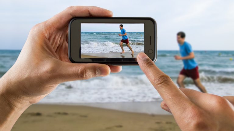 Smartphone-Kamera filmt Jogger am Strand