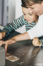 Mutter und Tochter beim Kochen mit projizierter Kochanleitung auf der Arbeitsfläche