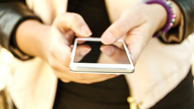 Nach Update: Mehr reden, weniger tippen mit der Spracheingabe von Gboard für iOS. Frau bedient Smartphone.