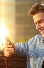 Junge mit Smartphone schaut Film.
