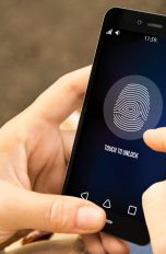 Frau bedient Smartphone per Fingerprint.
