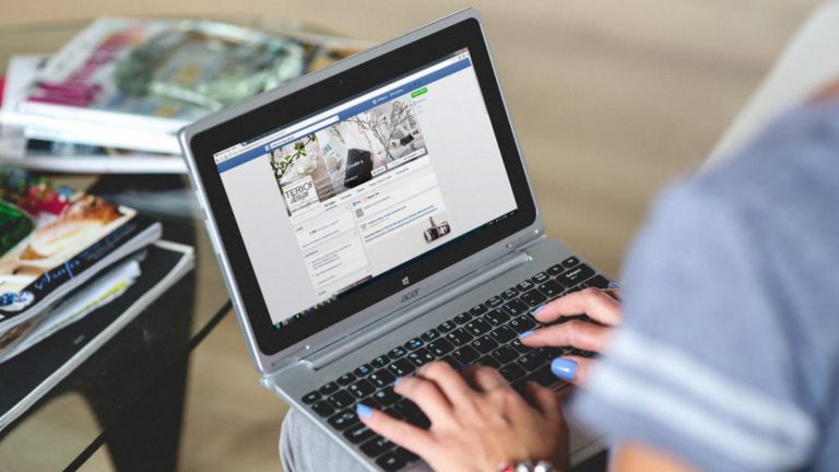 Userin surft auf einem Laptop durch Facebook