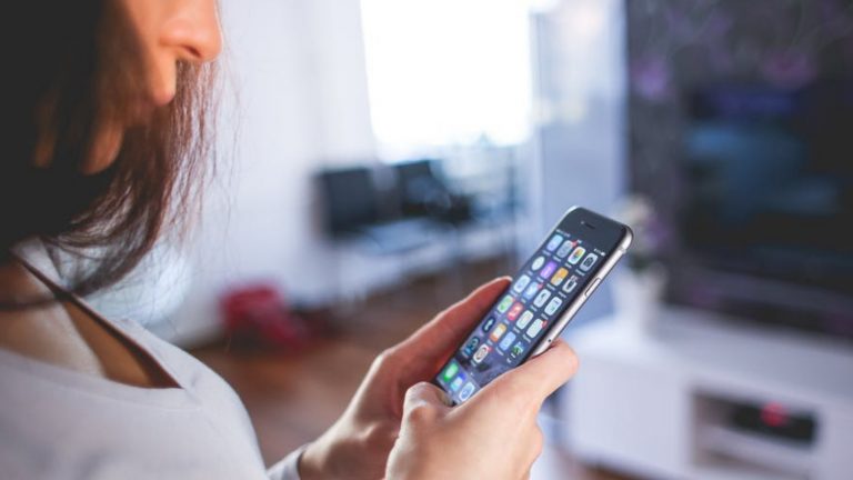 Frau mit iOS auf Smartphone