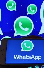 WhatsApp-Logo auf Bildschirm und Smartphone