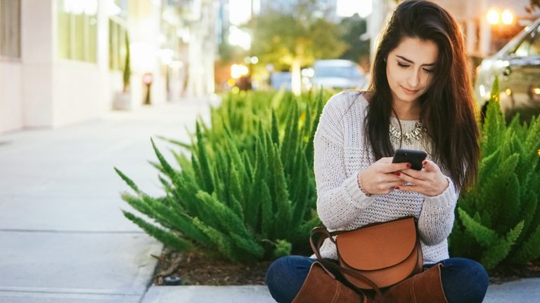 Eine Frau liest auf ihrem Smartphone