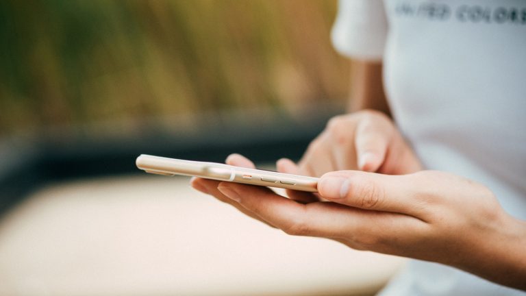 Frau tippt Nachricht auf einem iPhone mit iOS 11 Frau tippt Nachricht auf einem iPhone mit iOS 11
