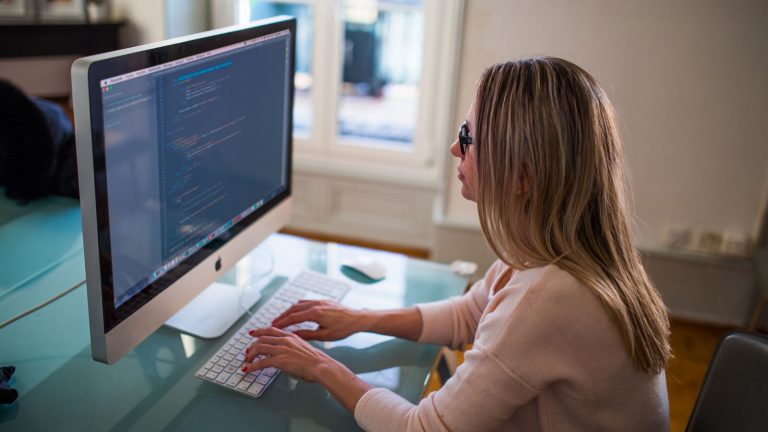 Frau sitzt am frisch eingerichteten iMac