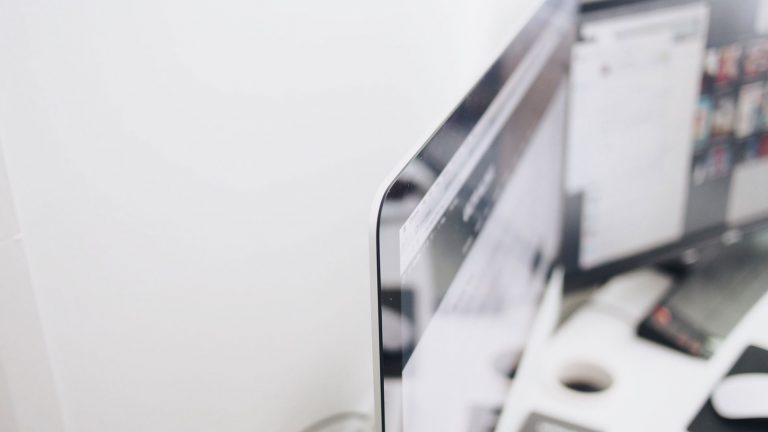 Zwei Personen betrachten einen PC-Monitor im Büro