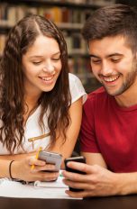 Paar mit Smartphones in Bibliothek