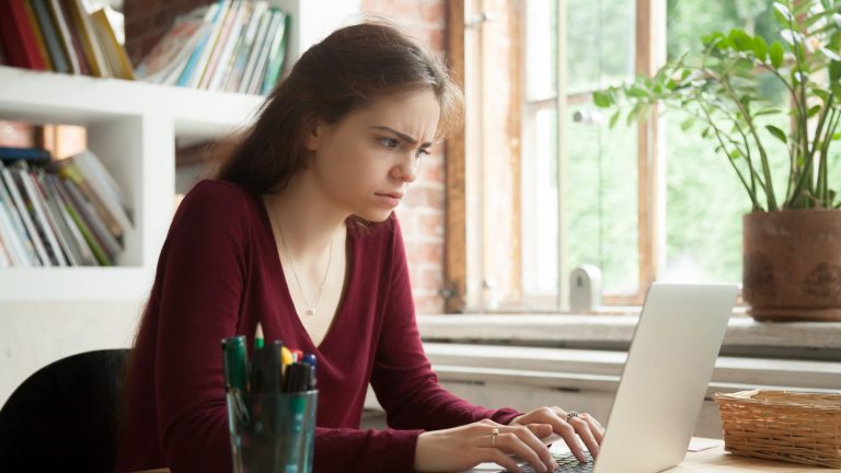 Windows 10 im abgesicherten Modus starten Junge Frau sitzt nervös vor ihrem Computer