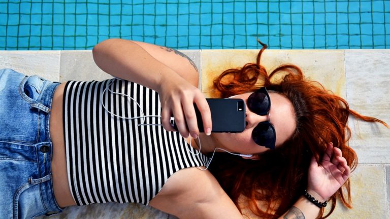 Junge Frau hört Musik über Smartphone