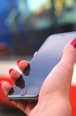 Smartphone wird unterwegs in der Hand gehalten