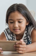 Kind schaut auf ein Smartphone