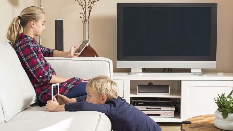 Handys für Kinder Sucht Mädchen und Junge gucken auf Smartphone und Tablet