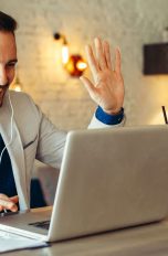 Mann nutzt Skype-Videochat am Laptop