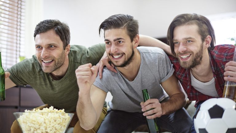 Drei junge Männer sehen gemeinsam Champions League im TV Drei junge Männer sehen gemeinsam Champions League im TV