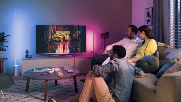 Familie guckt TV im Raum mit Philips Hue Signe