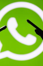 Smartphone-User vor WhatsApp-Logo