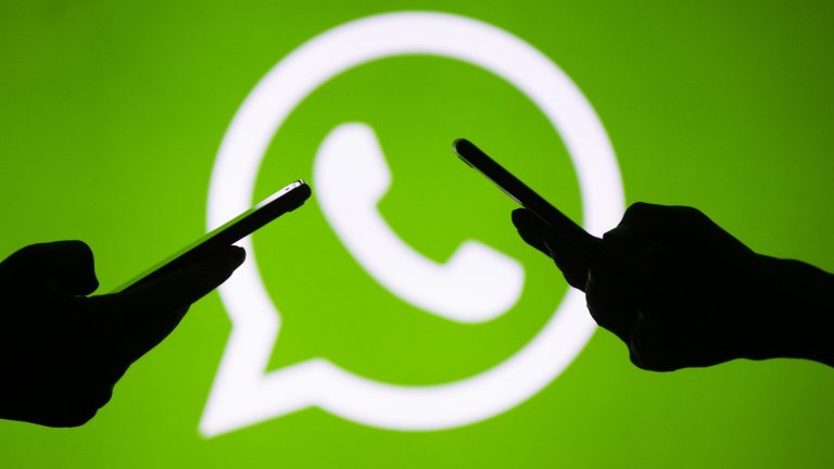 Smartphone-User vor WhatsApp-Logo
