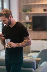 Mann mit Smartphone im Wohnzimmer