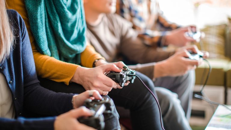 Familie und Freunde spielt mit Controllern und USB-Kabel zu viert Familie und Freunde spielt mit Controllern und USB-Kabel zu viert