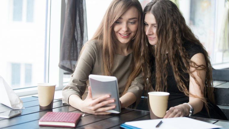 Zwei junge Frauen sehen gemeinsam ein Video auf einem Tablet Zwei junge Frauen sehen gemeinsam ein Video auf einem Tablet