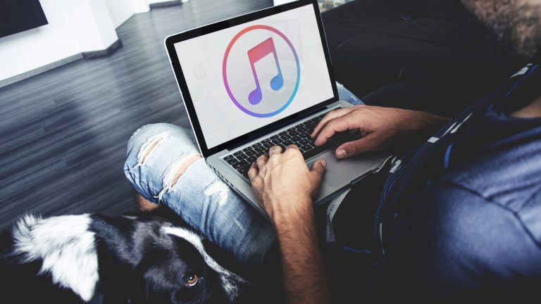 Junger Mann öffnet iTunes nach dem Back-up auf seinem MacBook