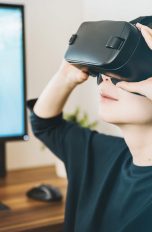Frau mit VR Brille sitzt vor PC