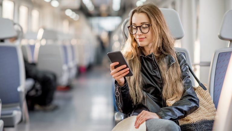 Huawei-ID erstellen: Erweiterte Möglichkeiten Frau guckt auf Smartphone