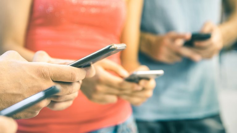 Vier Personen chatten auf dem Smartphone