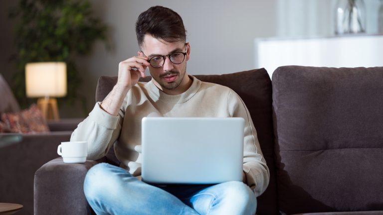 VPN-Server einrichten: Vorbereitung Junger Mann mit Laptop auf dem Sofa