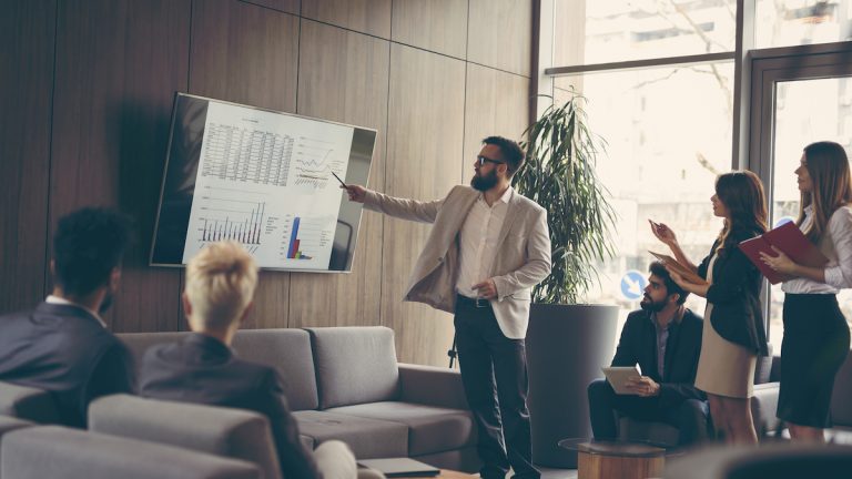 PowerPoint: Inhaltsverzeichnis - Präsentation Mann hält PowerPoint-Präsentation vor Kollegen