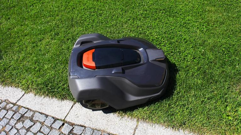 Ein Rasenmäherroboter mäht leise den Rasen Ein Rasenmäherroboter mäht leise den Rasen