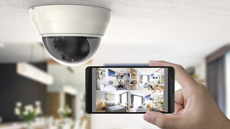Kamera für Haustiere an der Decke daneben ein Smartphone mit Kameraübersichten