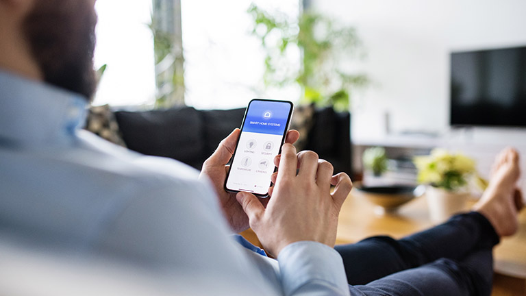 otto-smart-home-lichtschalter-inline1 Person mit Smartphone steuert smarte Beleuchtung
