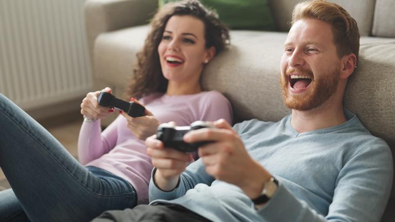 Pärchen spielt Konsole mit Gamer Equipment