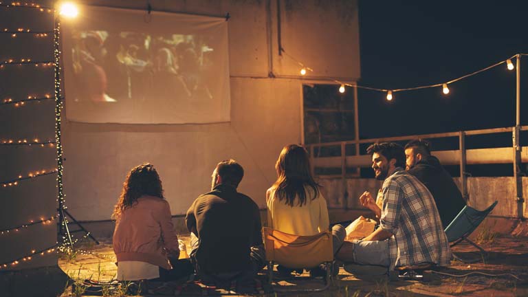 Heimkino selber bauen: Schritt für Schritt zum Kinoerlebnis Eine Gruppe junger Leute nutzt Heimkino im Freien