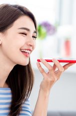 Frau benutzt Smartphone mit Google Assistant