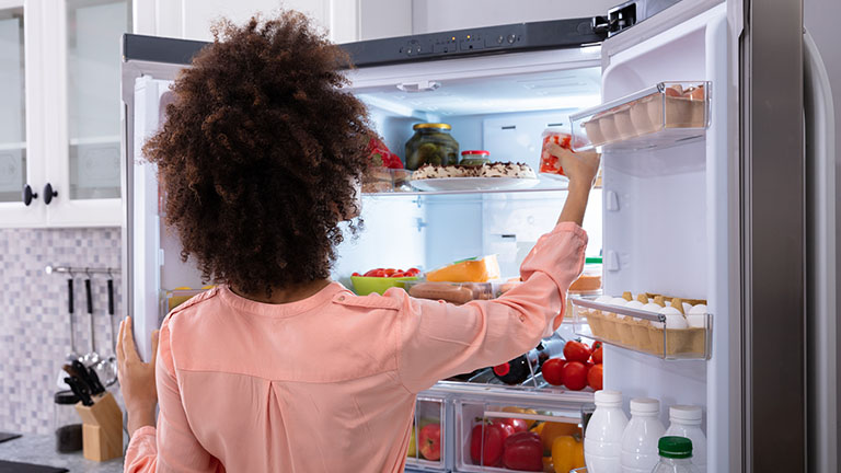 Frau steht vor Samsung Twin Cooling Kühlschrank