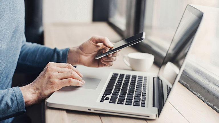 Mit diesen Tipps und Tricks verlängerst du die Akkulaufzeit deines MacBooks Mann arbeitet unterwegs am MacBook