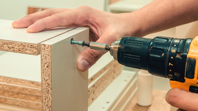 Beamer-Hushbox: Weniger Geräusche dank selbstgebautem Schallschutzgehäuse Heimwerker schraubt zwei Holzplatten aneinander